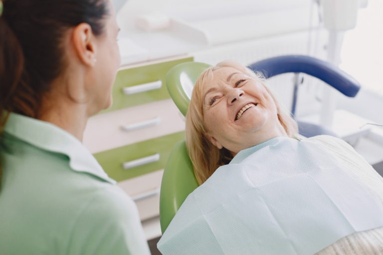 elderly person smiling with dentist